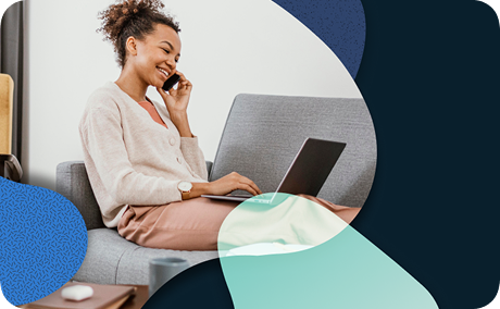 A person is sitting on a couch working on a laptop.