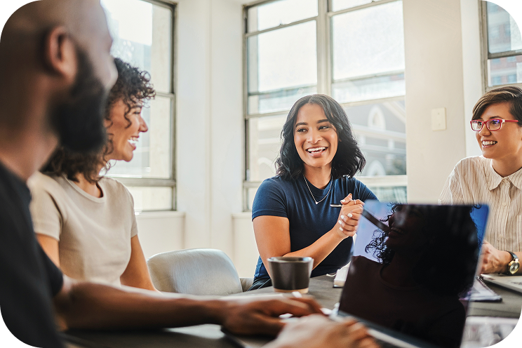 Four people smiling around a conference table.