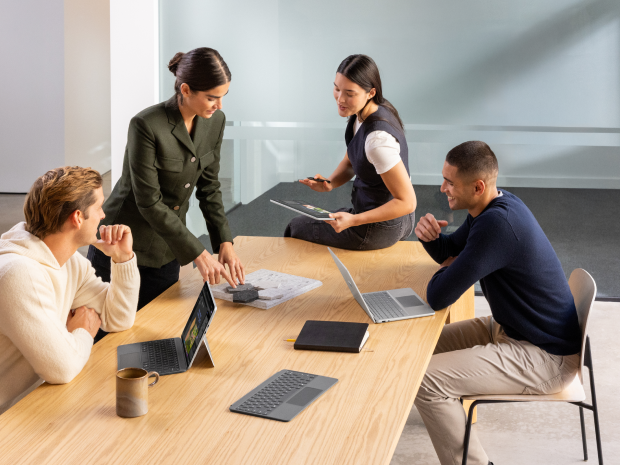 People working at a table together on computers