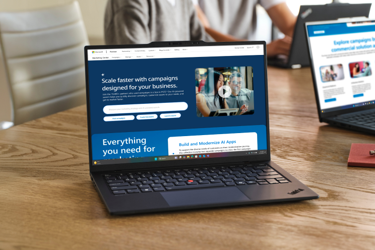 An open laptop shows a Microsoft partner website.