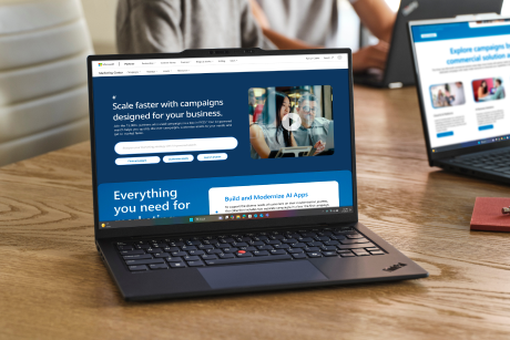 An open laptop shows a Microsoft partner website.